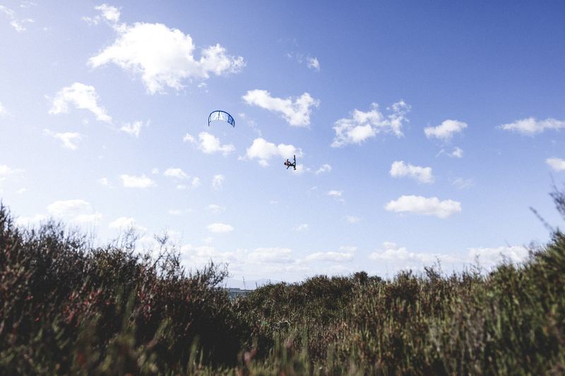 Paragliders over a wooded valley