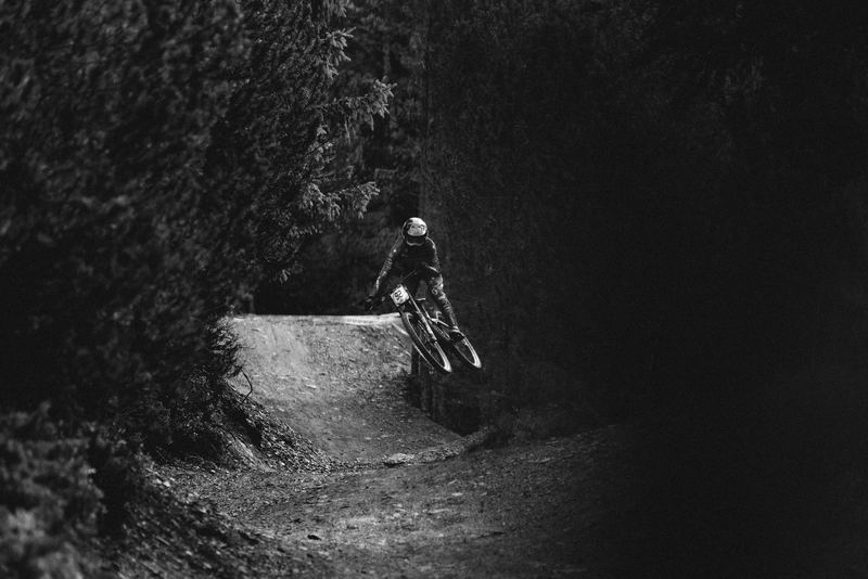 A mountain biker rolling a berm in the woods