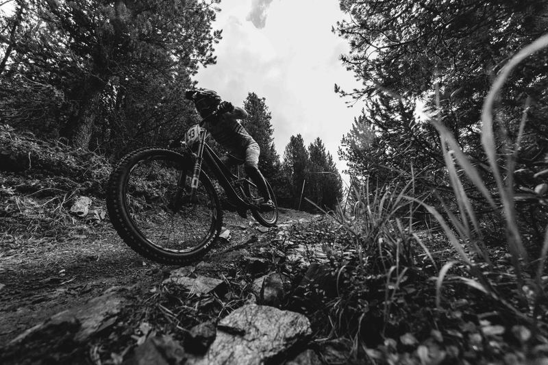 A mountain biker hopping across a rocky alpine slope