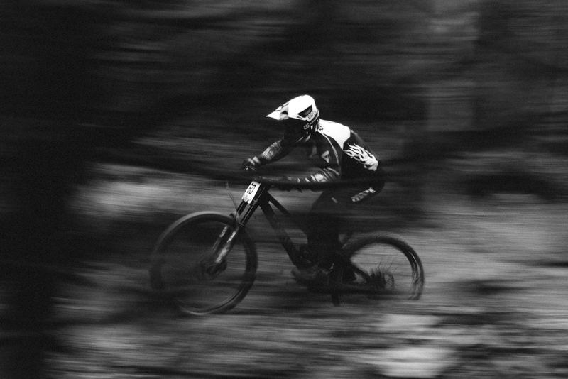 A downhill racer at speed, the background stretched by the pan