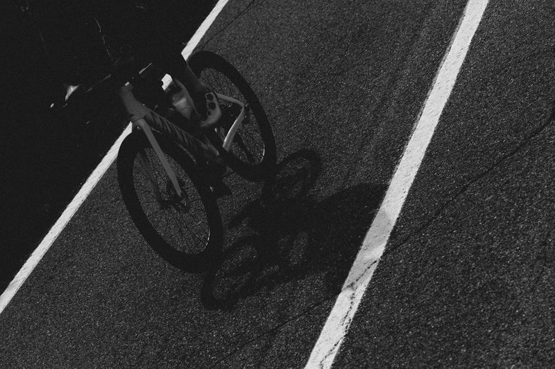 A road bike's shadow cast across white road markings