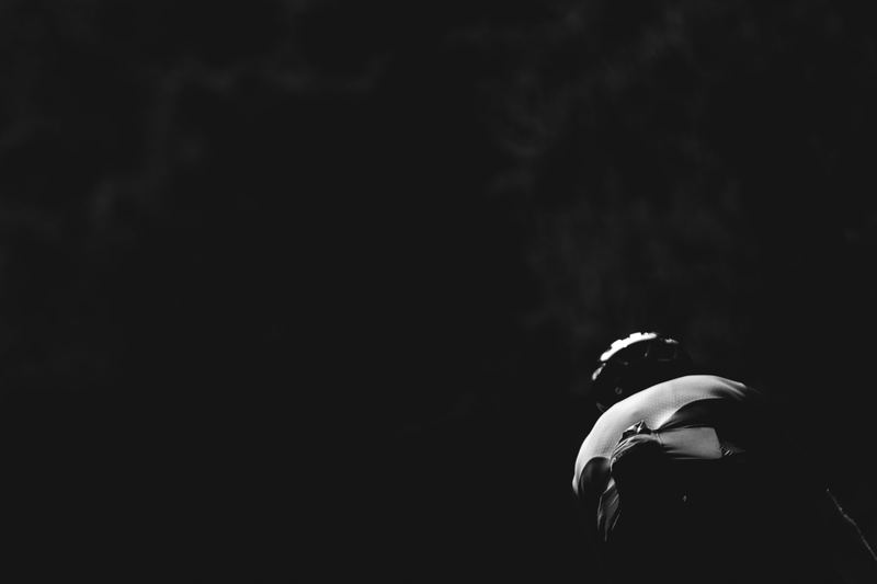 A snowboarder small against a dark slope