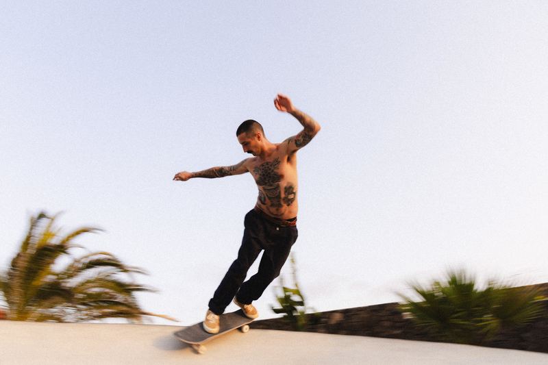 A skater on the poolside coping at sunset