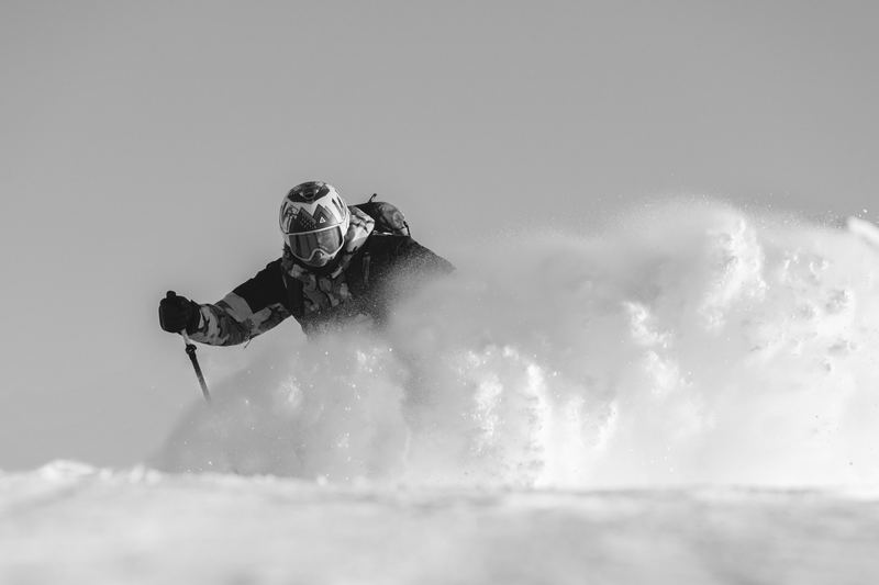 A snowboarder throwing powder toward the camera