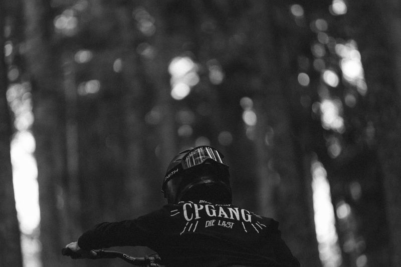A rider in a hoodie blurred through the pines