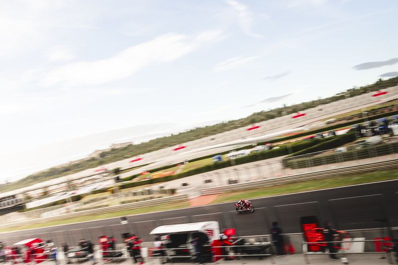 A circuit seen wide, pit lane and paddock below