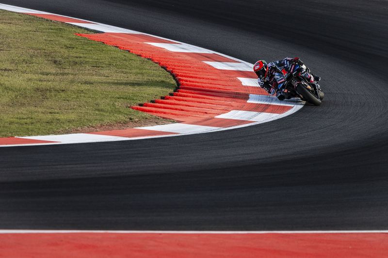 A MotoGP rider tipping into the red and white kerbs