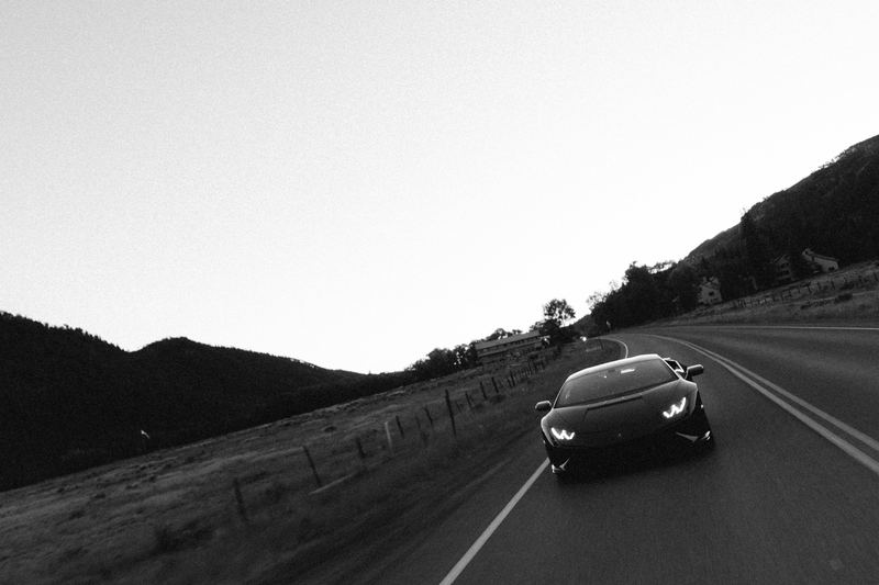 A Lamborghini running a mountain road at dusk