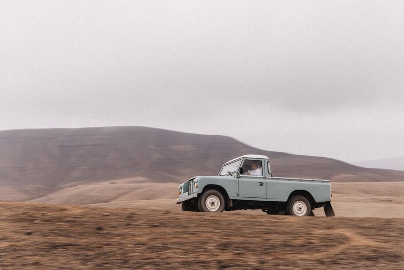 A vintage pickup parked on a dune crest in the desert