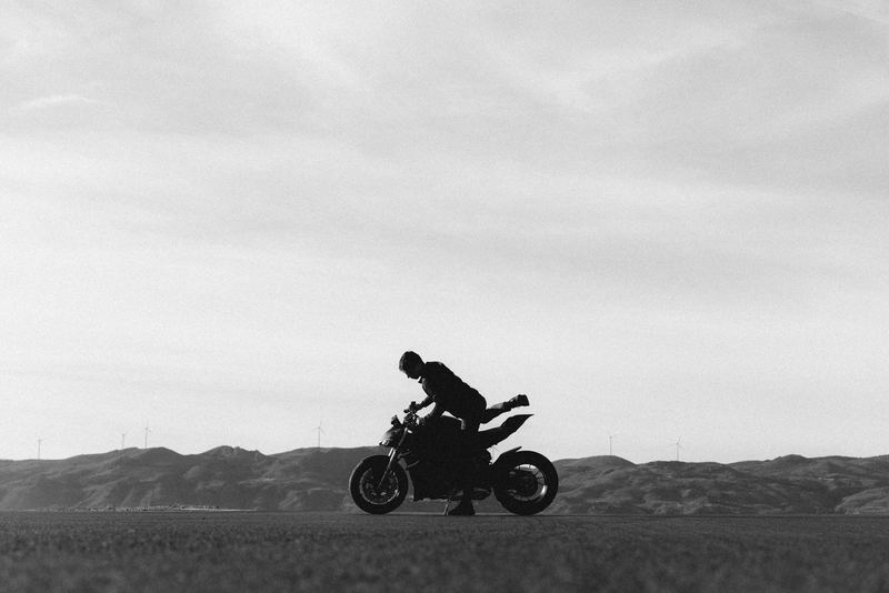 A motorcycle silhouetted against a bright horizon