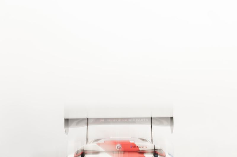 A car under a white cover in a bright studio