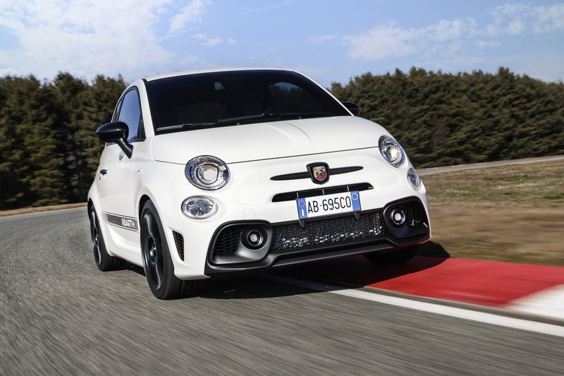 A white Abarth 695 cornering on a circuit