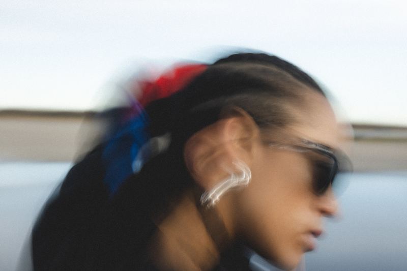 A woman in sunglasses, blurred by the pan
