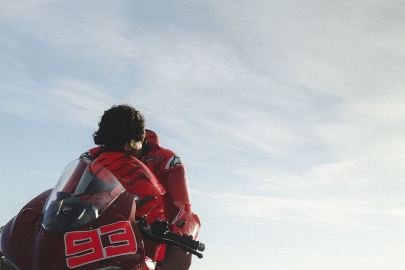 A racer in red leathers on the number 93 bike, seen from behind