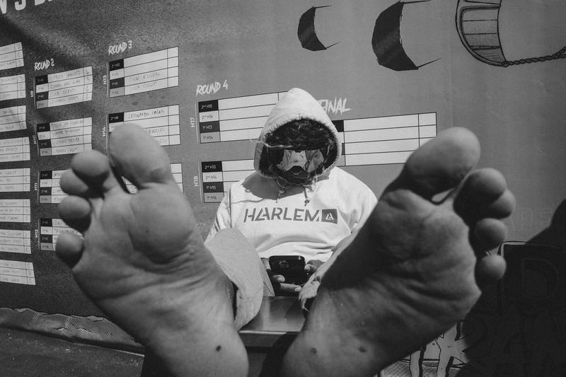 Bare feet on a table in front of a Harlem scoreboard