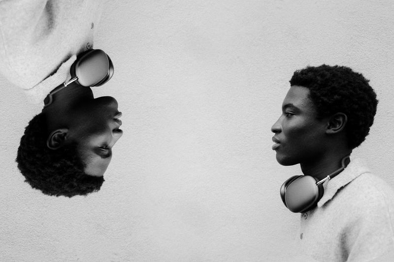 Two mirrored portraits of a young man with headphones